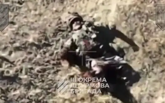 Russian invader rolls on field with severed arm. VIDEO