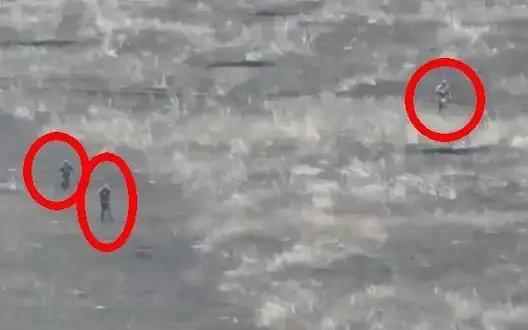 Three occupiers are walking in full length across field to assault under machine gun fire and drone attacks. VIDEO