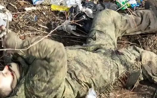 Russian invader kicks bucket in field wood lands littered with garbage after precise munition drop. VIDEO