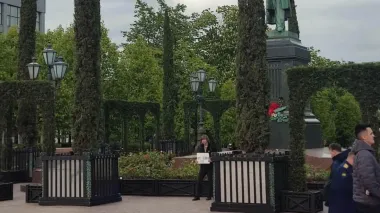 Police beat man holding "No to war!" placard in Moscow on Russia's Victory Day