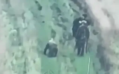 Two occupiers walking past their wounded accomplice, who is crawling towards them on all fours. VIDEO