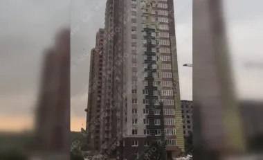 Непогода в Киеве: сильный ветер срывает фасад жилой многоэтажки (видео)